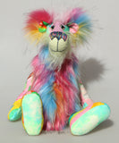 Plinkety Plonk by Barbara Ann Bears sitting down. He's a wildly colourful bear in printed fabric, long fluffy mohair and very long multi coloured faux fur.
