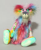 Plinkety Plonk by Barbara Ann Bears sitting down. He's a wildly colourful bear in printed fabric, long fluffy mohair and very long multi coloured faux fur.