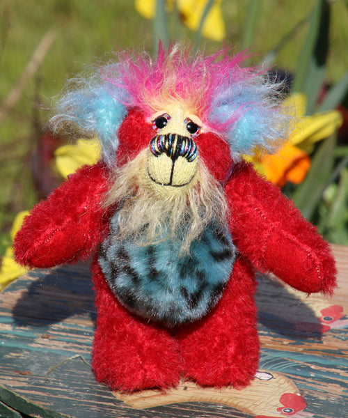 Rudi Ruffles is a very happy little teddy bear, a one of a kind, mohair and faux fur artist bear by Barbara-Ann Bears, is quite a little bear, he stands just 5.5 inches/14 cm tall. He is made from a short red German mohair, with hand dyed yellow and blue mohair and soft sky blue faux fur with black Jaguar-like rosettes