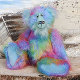 Syracuse sitting.
Syracuse is a large and beautifully coloured one of a kind artist bear by Barbara Ann Bears in luxurious multi-coloured fluffy faux fur and very long, turquoise mohair he stands 19 inches/48 cm tall