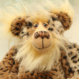 Tarzan McKenzie's face. He is a very fashionable and exotic, one of a kind, artist bear by Barbara-Ann Bears in leopard print faux fur and fluffy gold mohair. He has ochre felt paw pads, hand painted glass eyes, a beautifully embroidered nose and a huge smile.