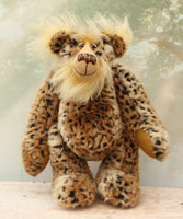 Tarzan McKenzie standing. He is a very fashionable and exotic, one of a kind, artist bear by Barbara-Ann Bears in leopard print faux fur and fluffy gold mohair. He has ochre felt paw pads, hand painted glass eyes, a beautifully embroidered nose and a huge smile.