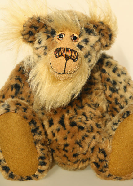 Tarzan McKenzie is a very fashionable and exotic, one of a kind, artist bear by Barbara-Ann Bears in leopard print faux fur and fluffy gold mohair. He has ochre felt paw pads, hand painted glass eyes, a beautifully embroidered nose and a huge smile.