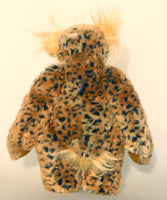 Tarzan McKenzie standing, back view. He is a very fashionable and exotic, one of a kind, artist bear by Barbara-Ann Bears in leopard print faux fur and fluffy gold mohair. He has ochre felt paw pads, hand painted glass eyes, a beautifully embroidered nose and a huge smile.