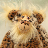 Tarzan McKenzie's face. He is a very fashionable and exotic, one of a kind, artist bear by Barbara-Ann Bears in leopard print faux fur and fluffy gold mohair. He has ochre felt paw pads, hand painted glass eyes, a beautifully embroidered nose and a huge smile.