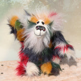 Tommy Truckle is a gentle and loving one of a kind, artist bear by Barbara-Ann Bears in luxurious mohair and beautifully colourful faux fur, he stands 11 inches/28 cm tall.  Tommy is made from faux fur in green, yellow ochre, red, cream and black, with a luxurious, long white fluffy mohair and hand dyed velvet paw pads