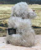 Wolfie sitting in profile.
Wolfie is a wild and groovy guy, a veteran artist bear from Barbara-Ann Bears in silvery grey English mohair, he stands 10 inches/25 cm tall. 