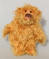 Plush teddy bear with a light brown fur texture on a grey background