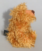 Plush teddy bear with curly fur on a grey background