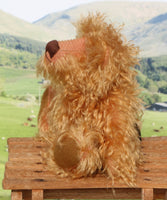 Plush teddy bear with a mountainous landscape in the background