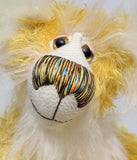 Alfredo Buttercup, a comical yet elegant yellow and white, one of a kind artist teddy bear in stunning hand dyed mohair by Barbara-Ann Bears. Alfredo Buttercup stands 17 inches (43 cm) tall and is 13 inches (33 cm) sitting. He is mostly made from a long and straggly mohair hand-dyed in sunny shades of yellow and gold.