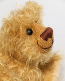 Bobbin has black boot button eyes, like the old teddy bears. He has a carefully embroidered nose and a warm beaming smile which gives him that puppy dog 'please pick me up and love me' expression