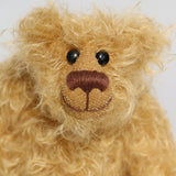 Bobbin has black boot button eyes, like the old teddy bears. He has a carefully embroidered nose and a warm beaming smile which gives him that puppy dog 'please pick me up and love me' expression