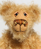 Brodie is a very sweet and friendly artist bear in wildly curly mohair by Barbara-Ann Bears, he stands 8.5 inches/21 tall and is 6 inches 15 cm sitting.  Brodie is made from curly beige gold mohair with brown wool felt paws, he has hand painted glass eyes with eyelids, a carefully embroidered nose and a beaming smile