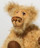 Brodie is a very sweet and friendly artist bear in wildly curly mohair by Barbara-Ann Bears, he stands 8.5 inches/21 tall and is 6 inches 15 cm sitting.  Brodie is made from curly beige gold mohair with brown wool felt paws, he has hand painted glass eyes with eyelids, a carefully embroidered nose and a beaming smile