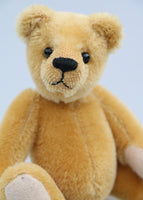 Cookie is made from dense, short, honey gold German mohair, he has black glass eyes and beige German wool felt paw pads which compliment his mohair beautifully. He has a pert, little, carefully embroidered brown nose and a gentle smile