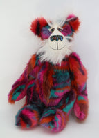 Delphine is a beautifully coloured, one of a kind, artist bear by Barbara-Ann Bears in luxuriously fluffy mohair and faux fur, she stands 18 inches/46 cm tall and is 14 inches/36 cm sitting. She's mostly made in a dense soft faux fur in wiggly bands of magenta, maroon, terracotta, turquoise, teal and dark purple. Her face, the fronts of here ears and the underside of his tail are a very long and fluffy white mohair
