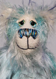  Dougal Dingle has beautiful hand painted eyes with eyelids, a nose embroidered from individual threads to complement his colouring and he has a huge, friendly smile. Dougal Dingle is mainly made from a fluffy, sparse mohair that Barbara has hand dyed a beautiful sky blue and his face the fronts of his ears and the underside of his tail are a long and fluffy white mohair with blue tipping. 