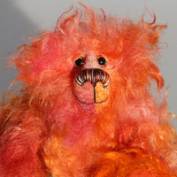 Flamin' Frizz has hand painted glass eyes with hand coloured eyelids. He has a carefully embroidered nose, sewn from individual threads to match the colouring of his mohair, and a warm beaming smile which gives him that puppy dog 'please pick me up and love me' expression