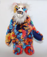 Floribunda is a magnificent, colourful one of a kind, artist teddy bear in fabulous faux fur and gorgeous mohair by Barbara-Ann Bears, he stands 19.5 inches/50 cm tall and is 15 inches/38 cm sitting. Floribunda is mostly made from a stunning piece of faux fur with a navy backing with swirls and flower motifs in gold, jade, cyan and red. His face, the fronts of his ears and the underside of his tail are made from a very long and fluffy white mohair