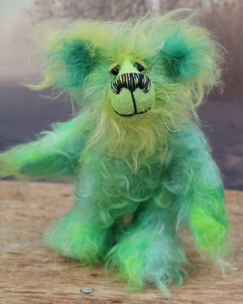 Freddo is a wonderfully happy and gorgeously green, one of a kind artist teddy bear by Barbara-Ann Bears in long and fluffy hand dyed mohair, he stands just 7.5 inches( 19 cm) tall and is 5.5 inches ( 14 cm) sitting.  Freddo is mostly made from a long distressed tousled mohair dyed jade, lime, emerald and bottle green