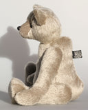 Frederick is a very sweet and cuddly, traditional teddy bear by Barbara Ann Bears, he stands 15.5 inches (39cm) tall and is 11.5 inches (29cm) sitting. Frederick is made from a silvery-grey German mohair with a straight, fairly short pile and a soft brown backing he has grey wool felt paws and vintage boot buttons eyes