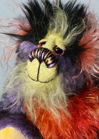 Geoffrey Sniggers has beautiful, hand painted eyes with eyelids, a splendid nose embroidered from individual threads to compliment his colouring and he has a sweet, friendly smileand on top of his head, Geoffrey has a fairly long and dense black faux fur from which plumes of very long orange, violet, magenta and yellow faux fur emerge, a bit like fireworks