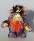 Geoffrey Sniggers is a little exceedingly happy one of a kind, mohair artist bear by Barbara-Ann Bears, he stands just 6 inches/15cm tall and is 5 inches/13 cm sitting. He's made from a black tipped violet mohair, mixed with orange and yellow hand dyed mohair and black faux fur on his head with long plumes of colour