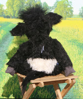 Gertie is mostly made from a fairly long and distressed black faux fur which is remarkably cow-like. Her tummy band is a fairly long and distressed white mohair and the fronts of her ears, nose and hoofs are a dark grey velvet. The top of her head and the tip of her tail are a much longer black faux fur.  Gertie has large clear glass eyes and is mostly stuffed with polyester stuffing, she has plastic pellets in her tummy and glass beads in her hoofs to make them a little heavier.