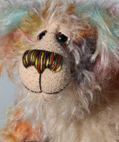 Herbie has beautiful hand painted glass eyes with eyelids, a pert nose embroidered with individual threads to match his mohair and an appealing smile. His face is a long tousled cream mohair and the fronts of his ears  and the underside of his tail are made from a longish distressed mohair hand dyed in blue with a little splash of pink
