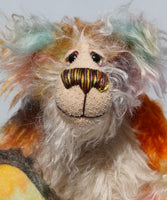 Herbie has beautiful hand painted glass eyes with eyelids, a pert nose embroidered with individual threads to match his mohair and an appealing smile. His face is a long tousled cream mohair and the fronts of his ears and the underside of his tail are made from a longish distressed mohair hand dyed in blue with a little splash of pink