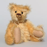 Honeynut is made from fairly long and fluffy, golden blond German mohair, he has old, black boot buttons for eyes and beige wool felt paw pads. He has a pert, little, carefully embroidered brown nose and the sweetest smile. Honeynut has plastic pellets in his tummy, arms and feet which makes him more pose-able and flexible