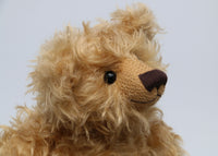 Humphrey is quite a large, classical teddy bear, he stands 18 inches (46cm) tall and is 13 inches (33cm) sitting. Humphrey is little bit wild to be a proper traditional teddy bear and he likes it that way. Humphrey is made from the most gorgeous long and wavy, dusky blond German mohair which comes to life in sunshine