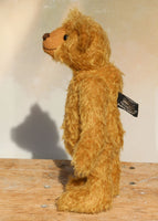 Jackson is a charming, traditional one of a kind mohair artist bear by Barbara Ann Bears, he stands 11.5 inches/29 cm tall and is 8.5 inches/22 cm sitting. Jackson is made from beautiful distressed antique gold German mohair, he has matching wool-felt paw pads and vintage boot buttons for eyes.
