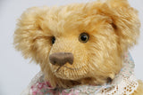 Jasmine is a very sweet and pretty one of a kind traditional mohair artist teddy bear by Barbara Ann Bears, she stands 13.5 inches (34 cm) tall and is 10 inches (25 cm) sitting. Jasmine is made from soft yellow mohair with mushroom coloured wool felt paw pads, green glass eyes, and she has a straw hat and lace collar.