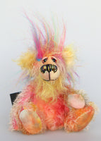 Jemermy is mainly made from a fairly short, quite sparse mohair hand dyed in many natural shades, pink and gold with splashes of purple and blue, his tummy and the underside of his tail are a longer mohair dyed in pinks and soft yellow, his face is a long mohair dyed a bright, happy yellow and the fronts of his ears are a denser, curlier mohair dyed a bright yellow. On top of his head there is a plume of long faux fur in blue, pink and yellow. Jeremy has hand dyed velvet paw pads. 