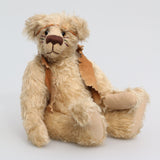 Jericho Joe is a youthful, playful teddy bear who likes to play and dress up, a veteran artist bear from Barbara-Ann Bears from the 1990s, he stands 12 inches (30 cm) tall and is 9 inches (23 cm) sitting. He was made from a pale beige German mohair, he has beige wool felt paw pads and pale amber translucent glass eyes