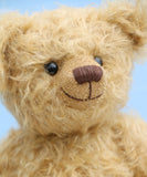 Josh is made from the most wonderful, wildly curly beige gold mohair, with a slightly warmer backcloth. Josh has black boot button eyes, like the old teddy bears. He has a carefully embroidered nose and a warm beaming smile which gives him that puppy dog 'please pick me up and love me' expression