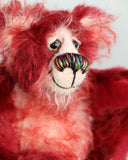 Krimbly Twinkles is mostly made from a medium length, fairly straight pile mohair in a beautiful deep cherry red, his face, tummy, the fronts of his ears and the underside of his tail are a wispy, fluffy, white mohair with red tipping. Krimbly Twinkles has deep red velvet paw pads which blend with his mohairs beautifully.  Krimbly Twinkles has beautiful, hand painted eyes with eyelids, a splendid nose embroidered from individual threads to compliment his colouring and he has a sweet, friendly smile