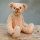 Maureen is a charming and traditional mohair artist bear by Barbara Ann Bears in beautiful pale peach coloured German mohair, stands 10 inches/25 cm tall and is 7.5 inches/18 cm sitting. She likes to think that she's a bit different from the other bears as she has a multicoloured nose and hand painted glass eyes