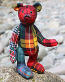 McTavish is made from a variety of Scottish tartan fabrics all backed with wool felt to make him stiffer and more durable. We bought the tartans as a bag of offcuts so we haven't been able to identify the clans they belong to. Barbara has carefully arranged the patterns so that they don't clash with each other and also to prevent tartans that are too similar appearing next to each other and his paw pads are also made from tartan.