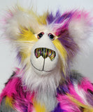 Miguel is mostly made from a very long, shaggy and dense faux fur which is black with bands of magenta, yellow, violet, grey and white. Miguel 's face, the fronts of his ears and the underside of his tail are made from a very long and soft white mohair.  Miguel has large, beautiful, hand painted glass eyes with hand coloured eyelids, he has a carefully embroidered nose that incorporates all of his colours and a sweet, thoughtful smile