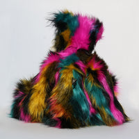 Milton is mostly made from a very long, shaggy and dense faux fur which is black with bands of magenta, mustard and cyan
