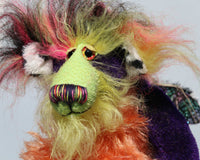 Mister Oofaloosy's face is made from long hand dyed mohair hand dyed lime green, the top of his head and the backs of his ears are a very long, black, pink and yellow faux fur and the fronts of his ears are a short, black spoted white animal print faux fur, he has beautiful, sparkling, hand painted glass eyes with hand coloured eyelids, a beautiful nose embroidered from individual threads to match his colouring and a sweet, enchanting smile