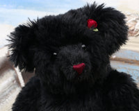 Portia is one of our very old bears, she's a sweet and cuddly, traditional teddy bear by Barbara Ann Bears, she is about 15 inches (38 cm) tall and is 11.5 inches (29cm) sitting. Portia is made from a beautiful, dense and shaggy, straight pile black English mohair her paw pads are made from a decorative cotton fabric 