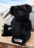 Portia is one of our very old bears, she's a sweet and cuddly, traditional teddy bear by Barbara Ann Bears, she is about 15 inches (38 cm) tall and is 11.5 inches (29cm) sitting. Portia is made from a beautiful, dense and shaggy, straight pile black English mohair her paw pads are made from a decorative cotton fabric 