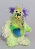 Rootin Tootin is made from several different fabrics, he's mostly a straight and sparse mohair that Barbara has hand dyed in beautiful shades of  lime and lime green. His tummy is made from a dense, soft faux fur in green tipped yellow, blue and lavender, his face is a long wispy pale yellow mohair, the fronts of his ears are a long fluffy violet and the underside of his tail is a long fluffy white mohair. Rootin Tootin has hand dyed velvet paw pads which match his colours perfectly. 