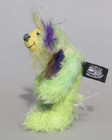 Rootin Tootin is made from several different fabrics, he's mostly a straight and sparse mohair that Barbara has hand dyed in beautiful shades of lime and lime green. His tummy is made from a dense, soft faux fur in green tipped yellow, blue and lavender, his face is a long wispy pale yellow mohair, the fronts of his ears are a long fluffy violet and the underside of his tail is a long fluffy white mohair. Rootin Tootin has hand dyed velvet paw pads which match his colours perfectly. 
