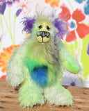 Rootin Tootin is made from several different fabrics, he's mostly a straight and sparse mohair that Barbara has hand dyed in beautiful shades of lime and lime green. His tummy is made from a dense, soft faux fur in green tipped yellow, blue and lavender, his face is a long wispy pale yellow mohair, the fronts of his ears are a long fluffy violet and the underside of his tail is a long fluffy white mohair. Rootin Tootin has hand dyed velvet paw pads which match his colours perfectly. 