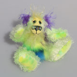 Rootin Tootin is made from several different fabrics, he's mostly a straight and sparse mohair that Barbara has hand dyed in beautiful shades of lime and lime green. His tummy is made from a dense, soft faux fur in green tipped yellow, blue and lavender, his face is a long wispy pale yellow mohair, the fronts of his ears are a long fluffy violet and the underside of his tail is a long fluffy white mohair. Rootin Tootin has hand dyed velvet paw pads which match his colours perfectly.